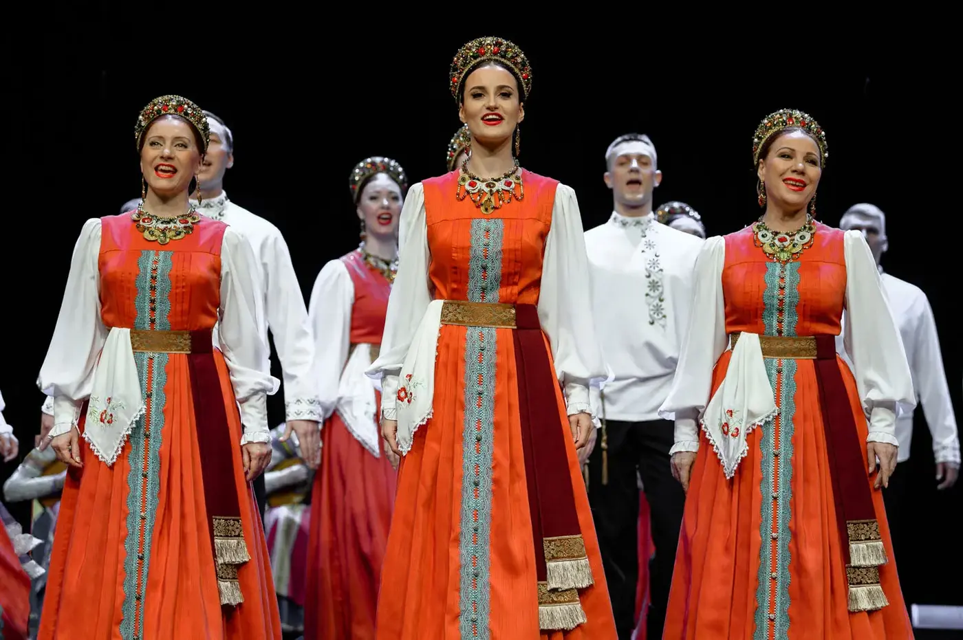 Народный хор в ярких традиционных костюмах на сцене